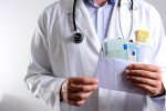 Arzt hält Kuvert mit Geldscheinen